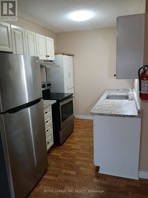 Niagara Falls (Downtown) fourplex for rent - A kitchen with a stainless steel refrigerator and a white countertop.