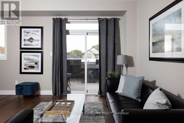 London South (South U) townhouse for rent - A living room with a black couch and a coffee table in front of a large window.