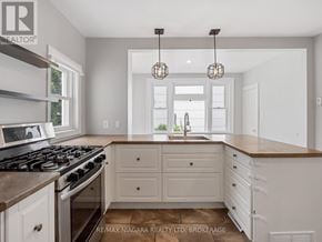 Fort Erie (Ridgeway) apartment for rent - A kitchen with a stove, cabinets, and a window.