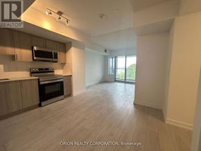 Toronto (Yorkdale-Glen Park) condo for rent - A spacious kitchen with wooden flooring and modern appliances.
