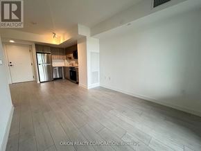 Toronto (Yorkdale-Glen Park) condo for rent - A spacious room with a kitchen area in the background.