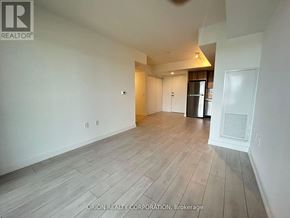 Toronto (Yorkdale-Glen Park) condo for rent - A spacious room with wood flooring and white walls.