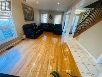 Toronto (Rouge) apartment for rent - A living room with a black leather couch and wooden floors.