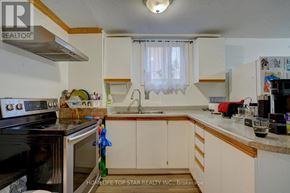 Toronto (Guildwood) apartment for rent - A kitchen with a black stove top oven and white cabinets.