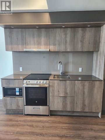 Mississauga (City Centre) condo for rent - A modern kitchen with a stainless steel oven and microwave.