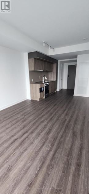 Mississauga (City Centre) condo for rent - A room with wooden flooring and a cabinet with a microwave and oven.