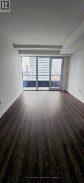Mississauga (City Centre) condo for rent - A room with wooden flooring and a large window.
