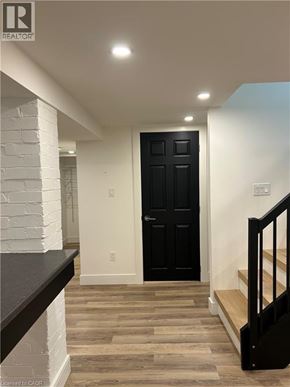 Hamilton apartment for rent - A black door is in a white room with wooden floors.