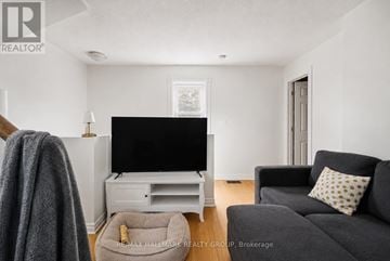 Ottawa triplex for rent - A living room with a grey couch and a flat screen TV.