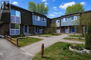 Ottawa townhouse for rent - A brochure for Exit Realty MATRIX Brokerage shows a building with a front yard and a fence.