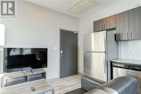 Waterloo condo for rent - A modern kitchen with stainless steel appliances and a flat screen TV.