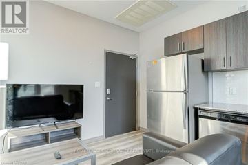 Waterloo condo for rent - A modern kitchen with stainless steel appliances and a flat screen TV.