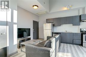 Waterloo condo for rent - A modern kitchen with a refrigerator, stove, and cabinets.