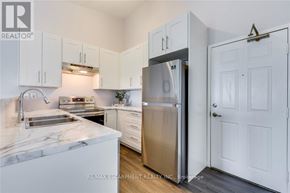 Burlington (Uptown) condo for rent - A kitchen with white cabinets and a marble countertop.