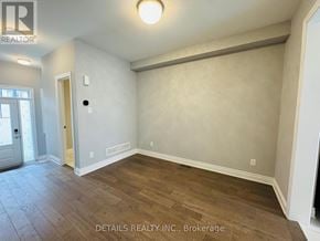Ottawa townhouse for rent - A room with wooden flooring and a door leading to another room.