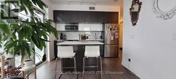 Toronto (Mimico) condo for rent - A kitchen with white chairs and a black counter.