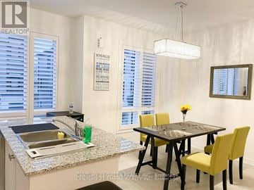 Whitby (Port Whitby) townhouse for rent - A kitchen with a table and chairs and a sign on the wall.
