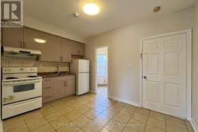 Toronto (Danforth) apartment for rent - A kitchen with white appliances and beige cabinets.