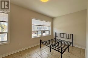 Toronto (Danforth) apartment for rent - A bedroom with a bed, window, and tiled floor.