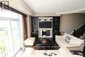 Toronto (Niagara) townhouse for rent - A living room with a white couch and a television.