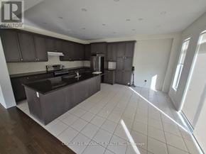 Whitby apartment for rent - A kitchen with dark brown cabinets and a black countertop.