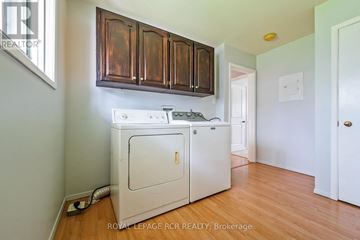 Orangeville apartment for rent - A white dishwasher is in a kitchen with wooden cabinets.