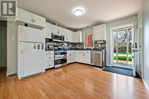 Orangeville apartment for rent - A kitchen with white appliances and wooden floors.