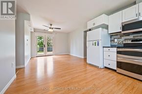 Orangeville apartment for rent - A kitchen with white appliances and wooden floors.