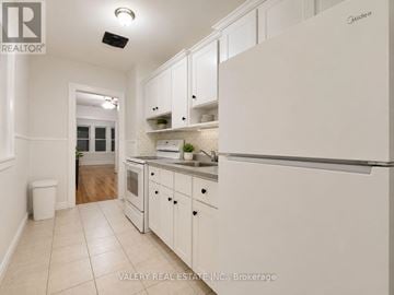 Windsor multi-family for rent - A kitchen with white cabinets and a white refrigerator.
