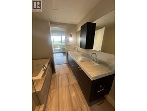 West Vancouver apartment for rent - A modern bathroom with a large mirror and a double sink vanity.