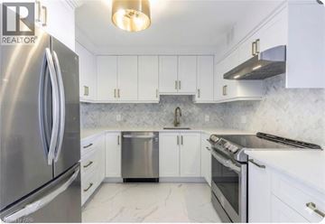 Burlington condo for rent - A kitchen with white cabinets and a stainless steel refrigerator.