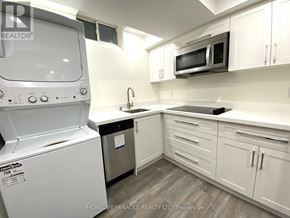 Whitby (Rolling Acres) apartment for rent - A white kitchen with a washing machine and a microwave.