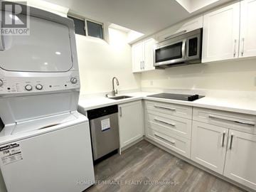 Whitby (Rolling Acres) apartment for rent - A white kitchen with a washing machine and a microwave.