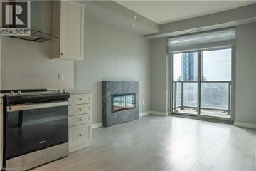 Kitchener condo for rent - A modern kitchen with a stove top oven and a fireplace.