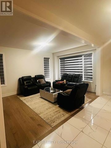 Peterborough (Monaghan Ward 2) apartment for rent - A living room with black leather furniture and a large window with blinds.