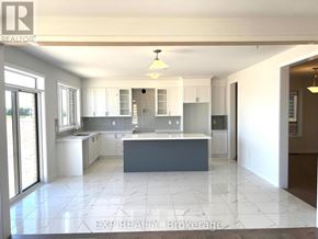 Peterborough (Monaghan Ward 2) apartment for rent - A kitchen with white cabinets and a large island.