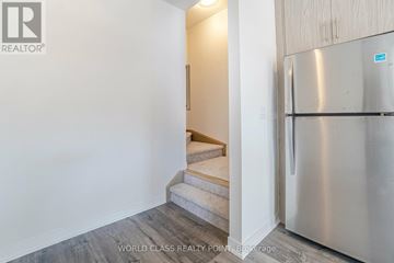 Mississauga (Erin Mills) townhouse for rent - A stainless steel refrigerator is in a kitchen with a staircase.