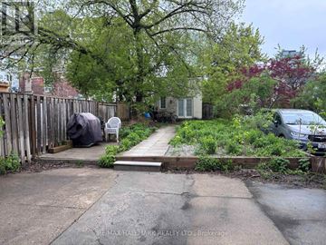Toronto (Kensington-Chinatown) apartment for rent - A backyard with a wooden fence and a small garden area.