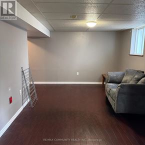 Clarington (Bowmanville) apartment for rent - A room with a grey couch and a wooden floor.