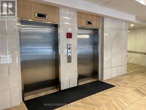 Toronto (Niagara) condo for rent - Two elevators in a hallway with a sign that says REALTOR.