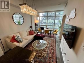 Toronto (Niagara) condo for rent - A living room with a white couch and a chandelier.