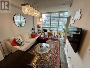 Toronto (Niagara) condo for rent - A living room with a white couch and a chandelier.