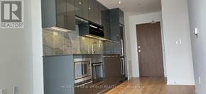 Toronto (Bayview Village) condo for rent - A modern kitchen with a marble countertop and stainless steel appliances.