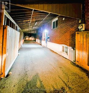 Toronto (Wexford-Maryvale) apartment for rent - A long, narrow, unfinished building with a brick wall and wooden fence.