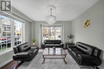 Brampton (Sandringham-Wellington) apartment for rent - A living room with black leather furniture and a chandelier.