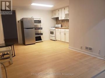 Toronto (Dovercourt-Wallace Emerson-Junction) apartment for rent - A kitchen with white appliances and wooden floors.