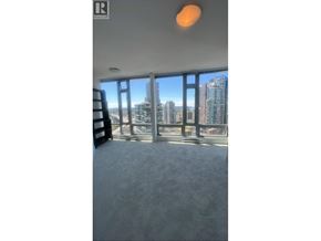 Vancouver apartment for rent - A room with a large window overlooking a cityscape.