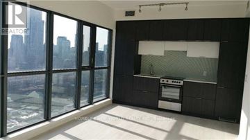 Toronto (Church-Yonge Corridor) condo for rent - A modern kitchen with a view of the cityscape outside the large windows.