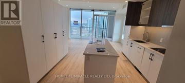 Kitchener condo for rent - A modern kitchen with white cabinets and a wooden floor.