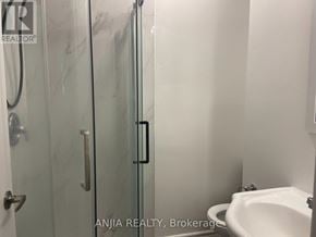 Toronto (West Hill) apartment for rent - A white toilet sits next to a glass shower door in a bathroom.
